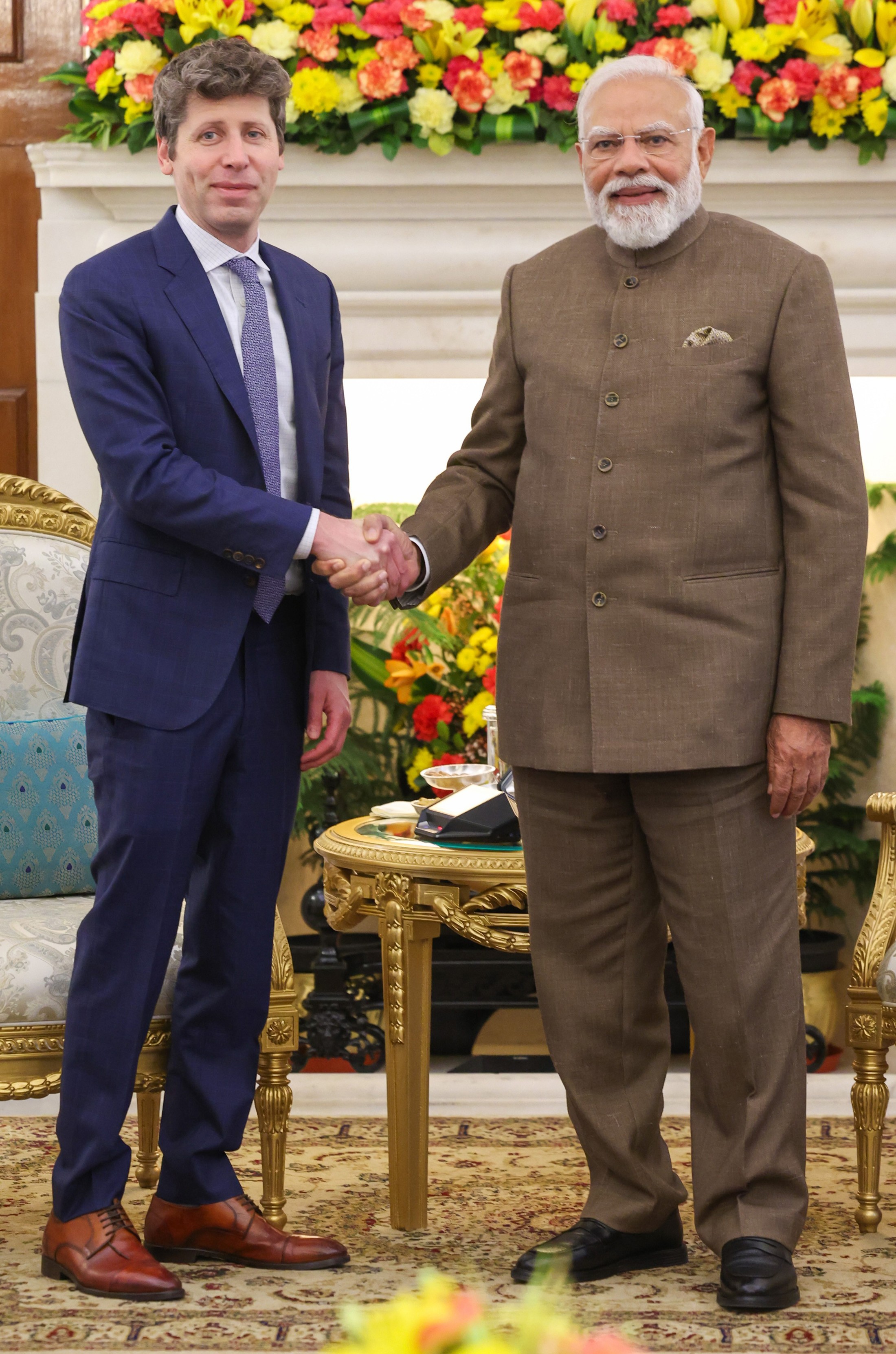 Narendra Modi e Sam Altman em pé numa sala com a bandeira da Índia ao fundo
