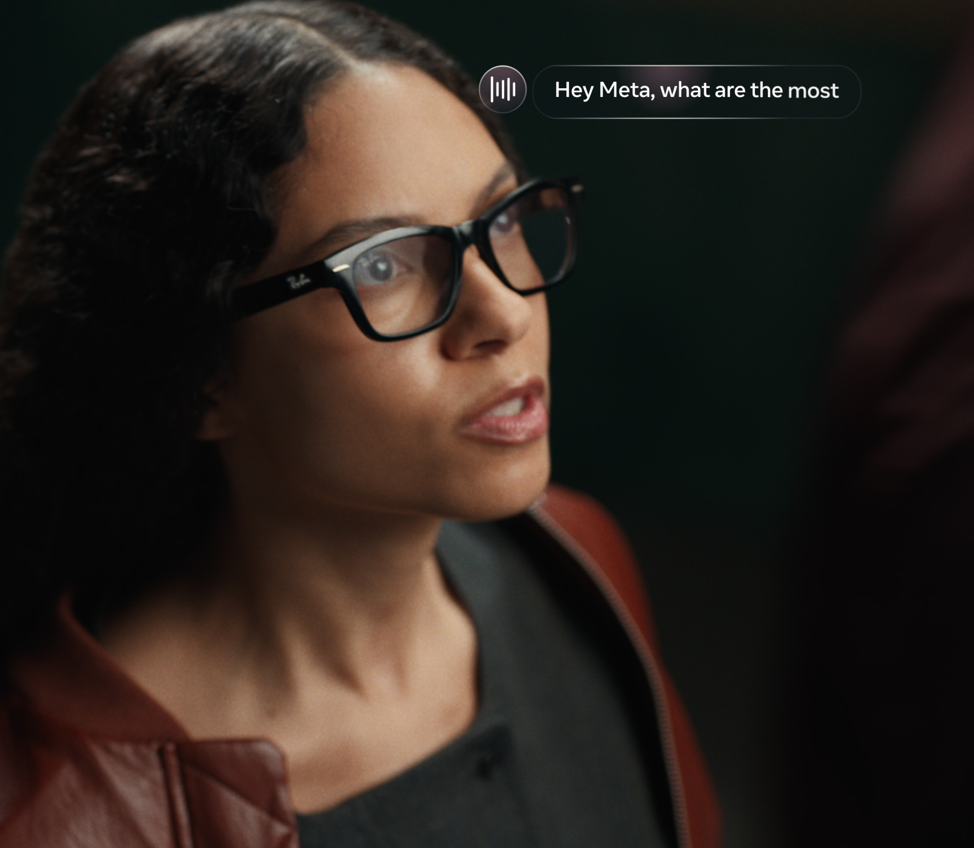 Mulher de perfil usando óculos Ray-Ban de armação preta com a parte superior mais grossa, em close, na imagem de divulgação do Ray-Ban Meta Audio
