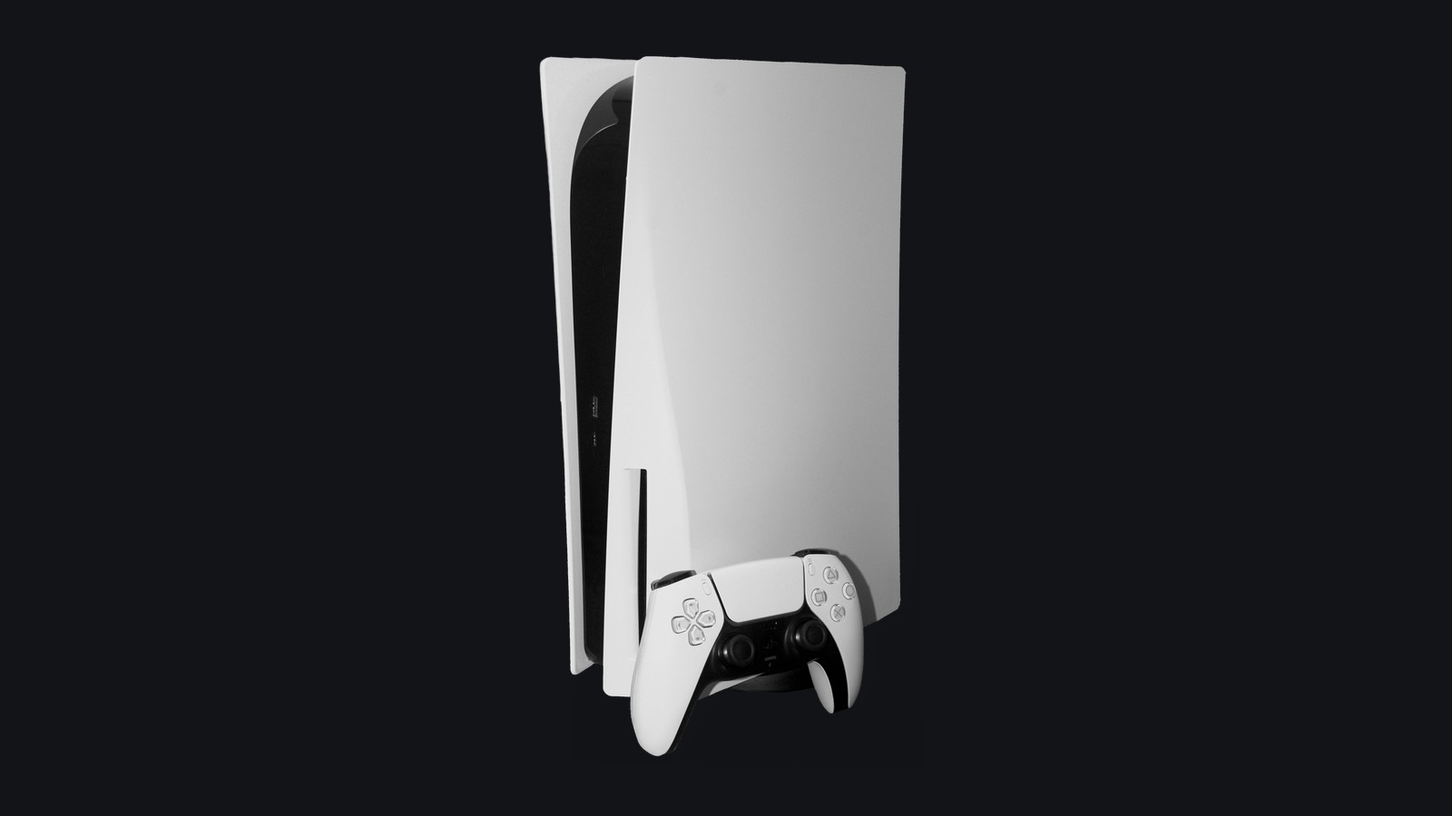 Console PlayStation 5 modelo base branco e preto com leitor de disco em posição vertical sobre fundo preto liso, acompanhado do controle sem fio DualSense repousado em sua base frontal